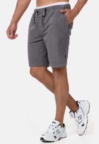 Grå kordfløjlshorts med elastisk talje og snøre, der har sidelommer og et diskret logo-tag i kanten.