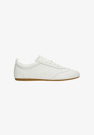 Witte sneaker met een lage profiel, een bovenwerk van glad leer, ronde neus, platte vetersluiting en een lichtbruine rubberen zool.