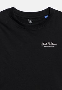 Μαύρο T-shirt με λαιμόκοψη crew και λευκό κείμενο "Jack & Jones Archive Selection" στην αριστερή πλευρά του στήθους, καθώς και μικρό γραφικό πρόσωπο σκύλου μέσα στον γιακά.
