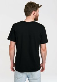Černé bavlněné tričko s kulatým výstřihem, krátkými rukávy a rovním lemem. Zadní strana má hladkou strukturu a žádné další vzory.