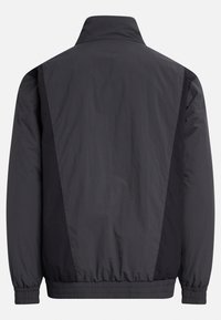 Lightweight, black jacket featuring a high collar, elastic cuffs, and a gathered hem. Smooth fabric with contrasting textured side panels.