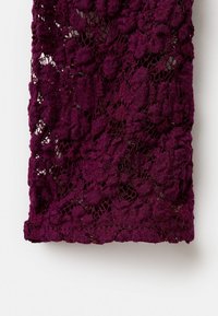 Purple lace fabric featuring a floral pattern, with a textured surface, delicate detailing, and a raw edge at the bottom.