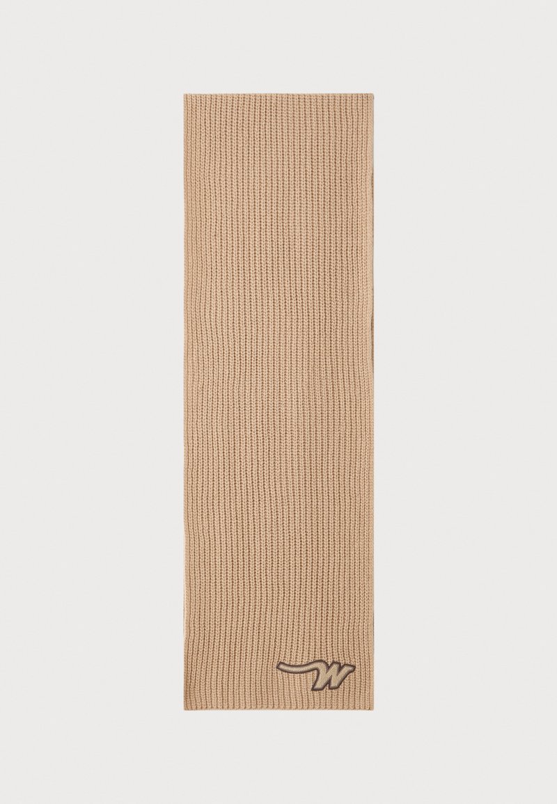 Sciarpa beige lavorata a maglia con un design a coste testurizzate e un piccolo logo marrone accentato in basso. Forma lunga e rettangolare.