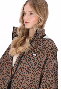 Barna és fekete leopárdmintás dzseki magas gallérral, cipzáras záródással és logó részlettel. Sima, könnyű anyagból készült.