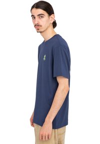 Navy blue cotton T-shirt with a crew neck, short sleeves, and a small green tree logo on the left chest. Smooth texture, regular fit.