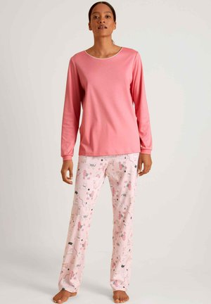 Roze langemouwen top met een ronde hals gecombineerd met roze pyjamabroek met een speels dierenpatroon in zwart en grijs.