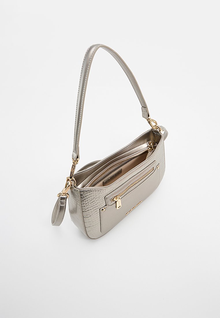 Kleine metallische silberne Handtasche mit strukturiertem Seitenteil, vorderer Reißverschlusstasche, goldenen Beschlägen und einem einzelnen Schulterriemen auf einem weißen Hintergrund.