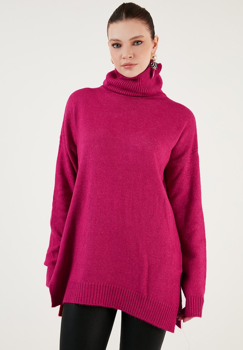 Punainen turtleneck-neule pitkähihaisilla hihoilla, ribbaustakeella ja helmalla. Löysä malli, jossa on sivuhalkiot, valmistettu pehmeästä, teksturoidusta kankaasta.