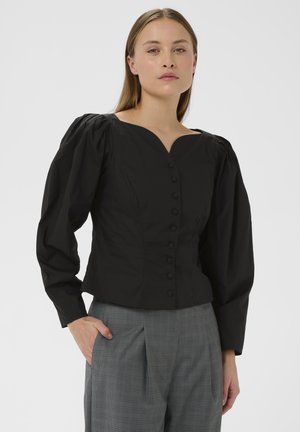 Blouse noire à manches bouffantes avec un décolleté en V profond et une fermeture à boutons. Fabriquée dans un tissu lisse, elle présente des coutures structurées pour un look ajusté.