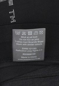 Zwarte reflecterende lange tights met een gladde textuur, met een zorglabel in het grijs met wasinstructies en een link naar de website.