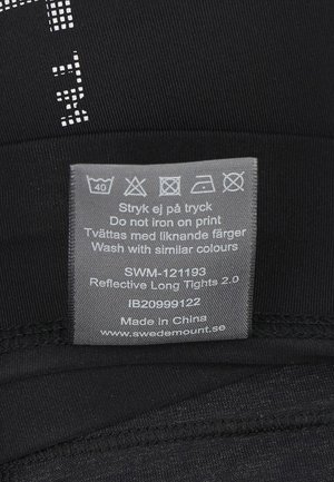 Zwarte reflecterende lange tights met een gladde textuur, met een zorglabel in het grijs met wasinstructies en een link naar de website.