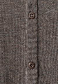 Brunstickad kardiagan med en texturerad tyg och ribbad kant samt två främre knappar med fyra hål.