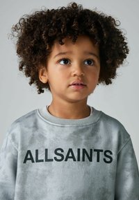 Pilkas džemperis su minkšta, tekstūrinėmis savybėmis ir reljefiniu apykakle, ant krūtinės puikuojasi drąsus juodas tekstas "ALLSAINTS".