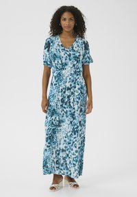 Abito maxi fluido in tessuto leggero con un motivo astratto blu e bianco. Scollo a V, maniche corte a sbuffo e vestibilità rilassata.