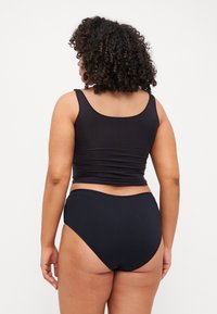 Black sports bra and high-waisted underwear made from stretchy fabric. Bra features wide straps, smooth texture, and fitted design.
