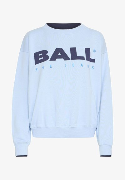 Gaiši zils džemperis ar apaļu kaklu, kritušiem pleciem un drosmīgām tumši ziltām burtiem, kas raksta "BALL THE JEANS", ar ribotām aprocēm un apakšmalu.