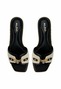 Black and white slide sandals featuring a woven texture, gold chain accent, and a square toe design. The inner lining is black leather.