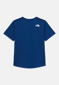 T-shirt azul de manga curta feito de algodão. Possui uma bainha arredondada e um pequeno logótipo branco na parte superior das costas. Textura suave, design casual.