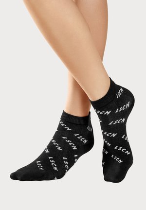 Schwarze Knöchelsocken mit wiederholtem weißen Text "LSCN" und geripptem Bündchen. Weiches Gewebe mit glatter Textur.