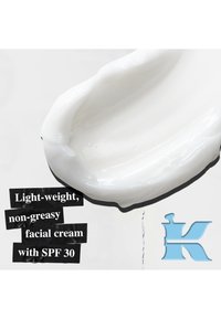 Lett, ikke-fet hvit ansiktskrem med SPF 30, vist i en jevn, tykk tekstur mot en lys bakgrunn med svart tekst.