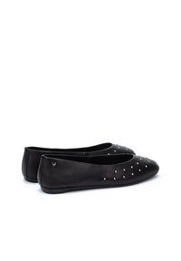 Bailarinas de cuero negro con punta afilada, adornadas con pequeñas tachuelas plateadas en la parte delantera; textura suave y suela flexible.