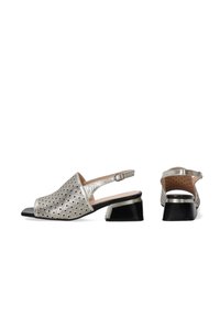 Metallisch silberne Slingback-Sandalen mit offener Zehe, geometrischen Ausschnitten, schwarzem Akzentabsatz und verstellbarem Riemen für eine optimale Passform.