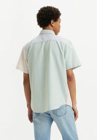 Korte mouw shirt met verticale strepen in groen, blauw en beige. Gemaakt van lichtgewicht katoen met een ontspannen pasvorm en een klassieke kraag.