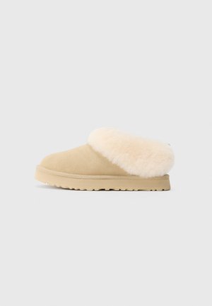 Béžové zamšové šľapky na slip-on so silným, mäkkým krémovým umelým kožúškom a pevným, textúrovaným gumovým podošvom.