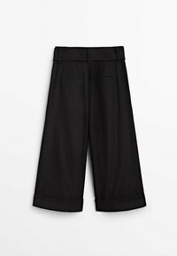 Zwarte wijde broek met een hoge tailleband, voorzien van twee voorplooien en opgerolde manchetten. Gemaakt van een gladde, lichte stof.