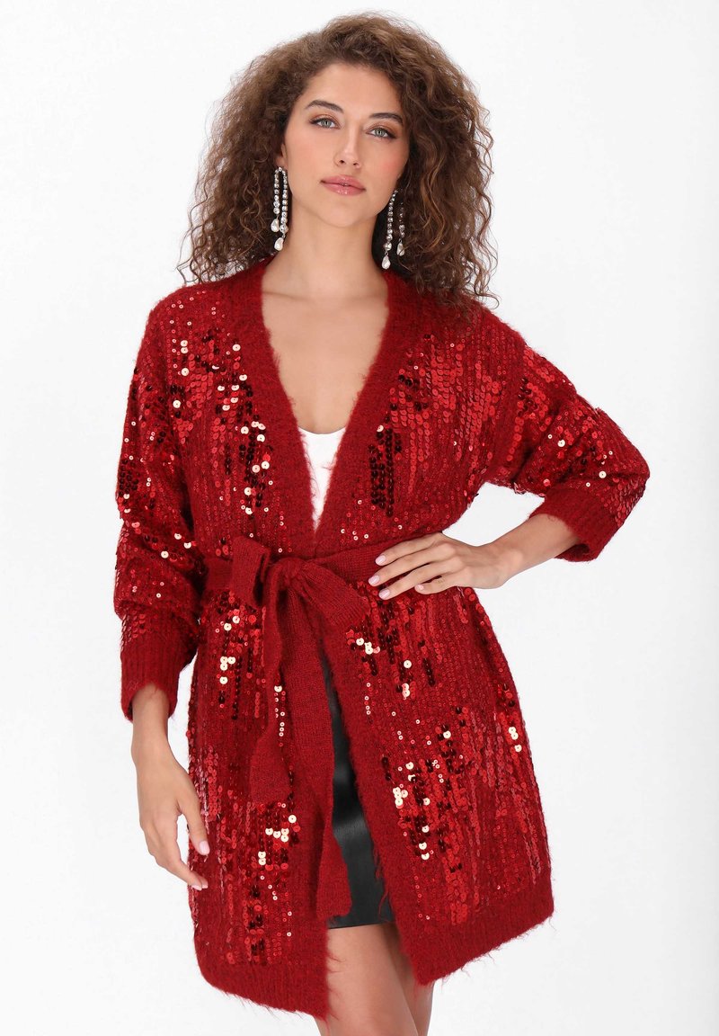 Czerwony kardigan z cekinami o pluszowej fakturze, otwarty z przodu, z długimi rękawami i dopasowanym paskiem, z połączeniem błyszczących i matowych cekinów.