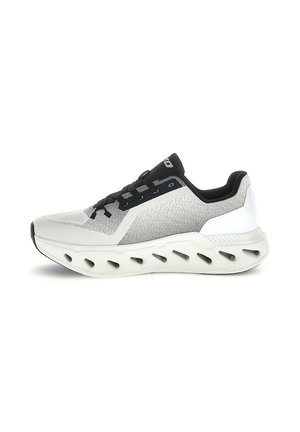 Scarpa sportiva grigio chiaro e nero con suola spessa e imbottita con più aperture ovali per la ventilazione e il supporto.