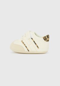Sneakers crema per bambini con dettagli a stampa leopardata, punta rotonda e strap elastico con strisce in pesca chiaro e nero.