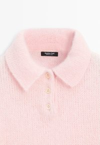 Světle růžový pletený polo svetr s jemnou texturou, vybavený klasickým límcem, třemi krémovými knoflíky a štítkem s nápisem "Massimo Dutti."