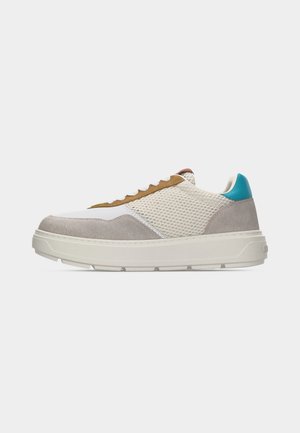 Sneaker basse con mesh bianco, pannelli in suede grigio, area delle stringhe marrone, toppa sul tallone turchese, suola bianca spessa e stringhe bianche, vista laterale.