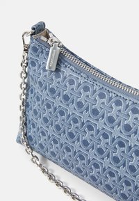 Kék szövet clutch táska, amely kiemelkedő logó mintával rendelkezik, ezüst cipzárral és ezüst lánc pánttal. Texturált felület sima kiegészítőkkel.