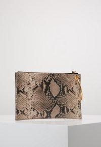 Borsetta a tracolla in beige e nero, design strutturato, superficie liscia, con zip e accessori in tonalità dorata.