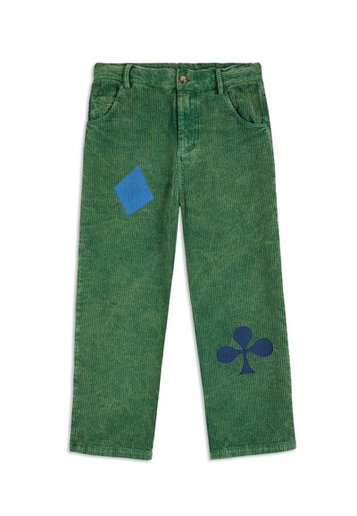 Pantalones de pana verdes con formas de diamantes y tréboles azules impresas en las piernas delanteras, que cuentan con bolsillos frontales y un cierre de botón.