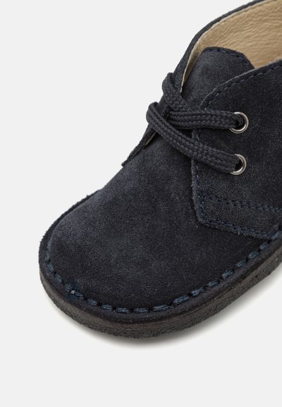 Pantof navy din suede pentru copii, cu vârful rotund, suprafață texturată, șireturi gri și cusături în contrast pe talpă.