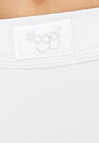 Witte elastische tailleband met een "slaggi" label; gladde textuur, aansluitend ontwerp, eenvoudige stijl zonder extra patronen of versieringen.