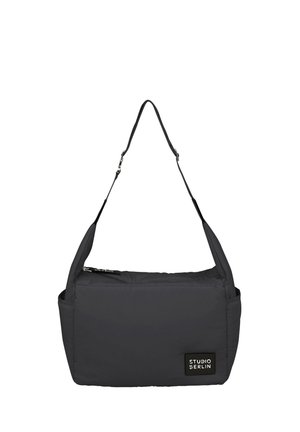 Melnas auduma soma ar taisnstūra formu, regulējamu plecu siksnu, priekšējo kabatu ar rāvējslēdzēju un zīmola etiķeti. Mīksta tekstūra, minimālisma dizains.