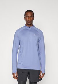 Nike lichtblauwe lange mouwen half-zip top, met raglan mouwen, vochtafvoerende stof en een klein wit logo op de borst.