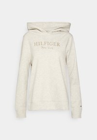 Světle béžová mikina vyrobená z měkké tkaniny, s klokaní kapsou, kapucí na šňůrku a vyšitým logem "HILFIGER New York" v zlaté barvě.