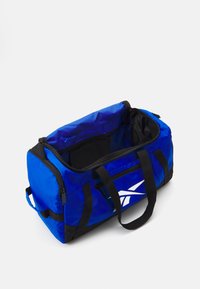 Geantă de duffel albastră fabricată dintr-un material durabil cu accente negre, având un compartiment principal spațios, o pungă cu fermoar și două mânere pentru transport.