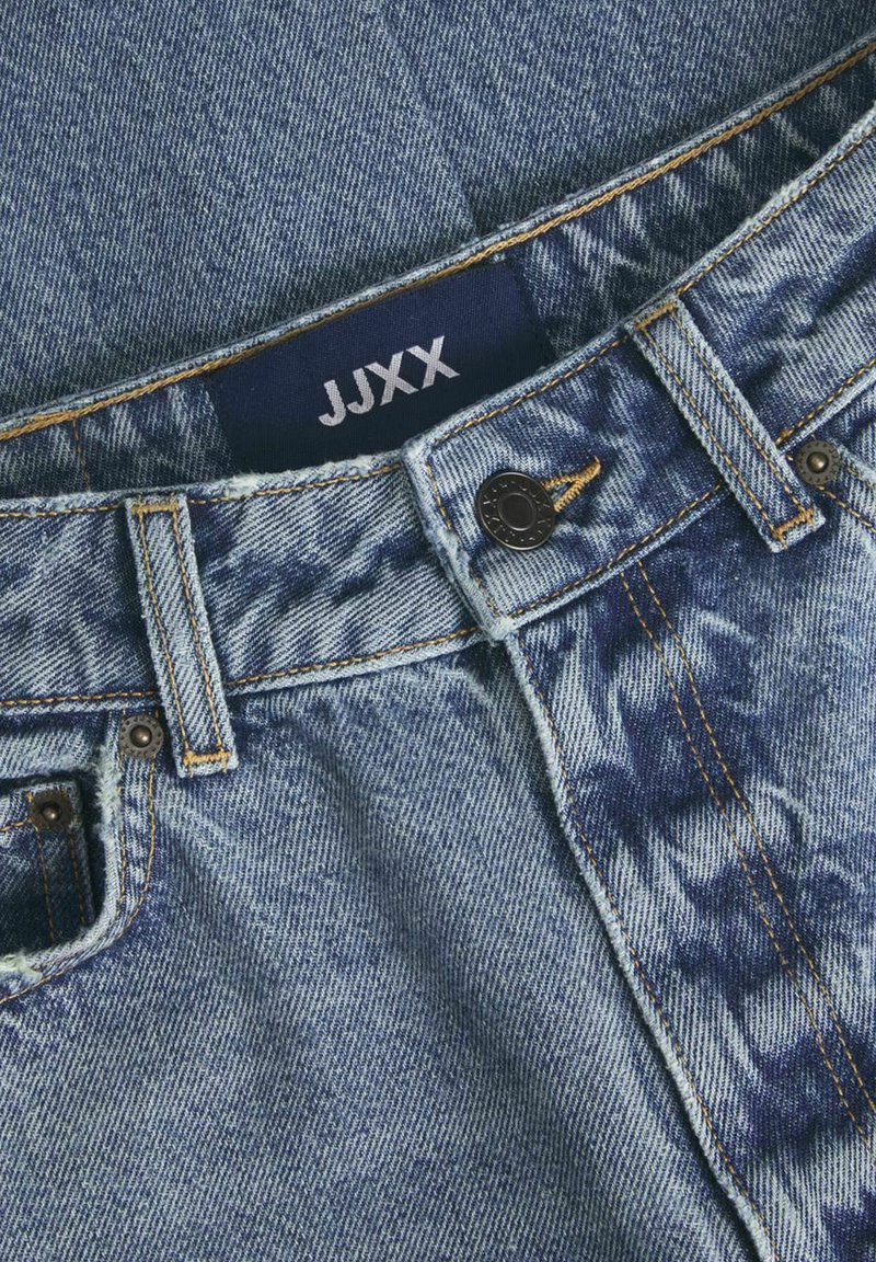 Jeans in denim con un lavaggio blu e chiaro, caratterizzati da un design a lavaggio scuro contrastante nella zona della tasca anteriore e con un'etichetta JJXX.