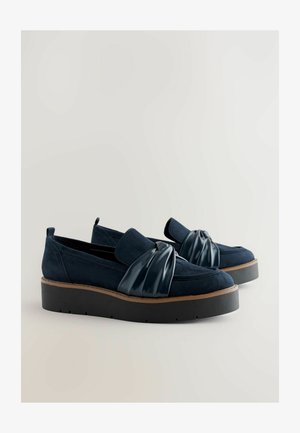 Námořnické modré semišové boty s lesklým zkrouceným syntetickým akcentem, disponující silnou černou platformou a šitými detaily.