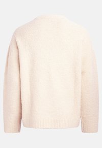 Cremfarbener Pullover mit flauschiger Textur, überschnittenen Schultern und rundem Halsausschnitt. Das Design verfügt über eine lockere Passform und einen gerippten Saum.
