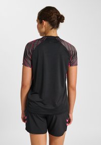 Czarny sportowy t-shirt z krótkim rękawem, z fakturowanym wzorem w kolorze różowym i szarym na ramionach. Do tego czarne szorty.