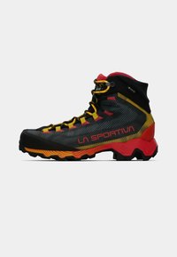 Czarno-czerwone buty outdoorowe z żółtymi akcentami, teksturowana syntetyczna cholewka, wysoka ochrona kostki i solidna podeszwa zapewniająca przyczepność.