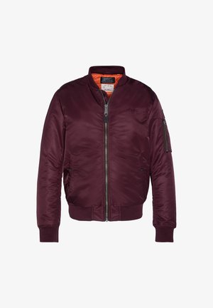 Veste bomber marron avec fermeture éclair à l'avant, poignets et bas côtelés, poche zippée sur la manche gauche et doublure orange à l'intérieur du col.
