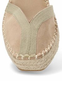 Zapato espadrille beige con parte superior de ante y tejido trenzado, suela de yute y diseño de tiras cruzadas con un acento de color claro y texturizado.